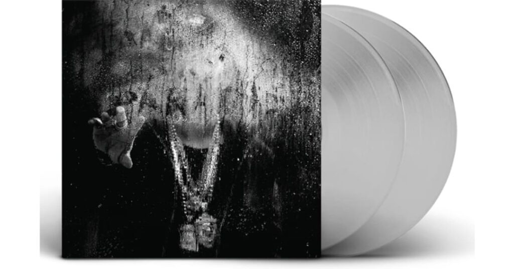 Big Sean's "Dark Sky Paradise" album cover with a black and white blurred figure behind a wet glass, adorned with heavy chains. Two clear vinyl records are shown.