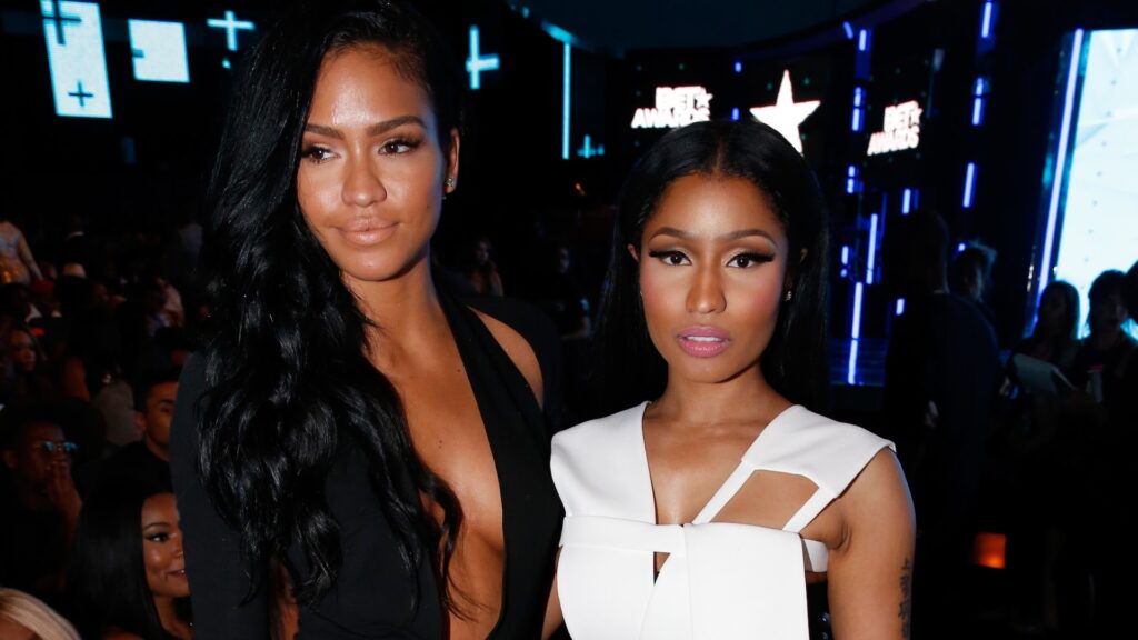 Cassie in a black dress and Nicki Minaj in a white outfit at an event, posing together.