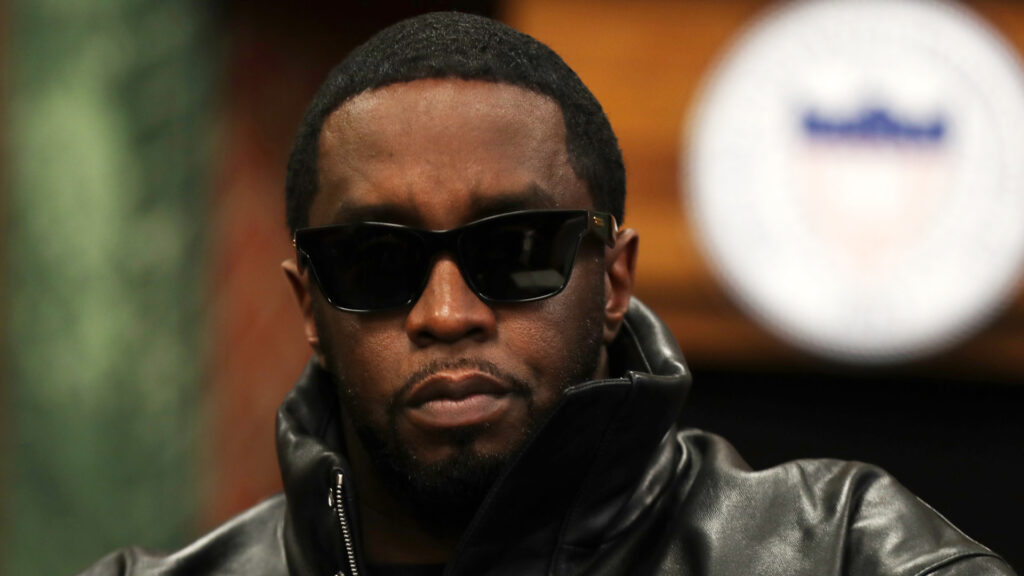 Sean Combs, also known as Diddy, wearing sunglasses and a black leather jacket, looking serious.