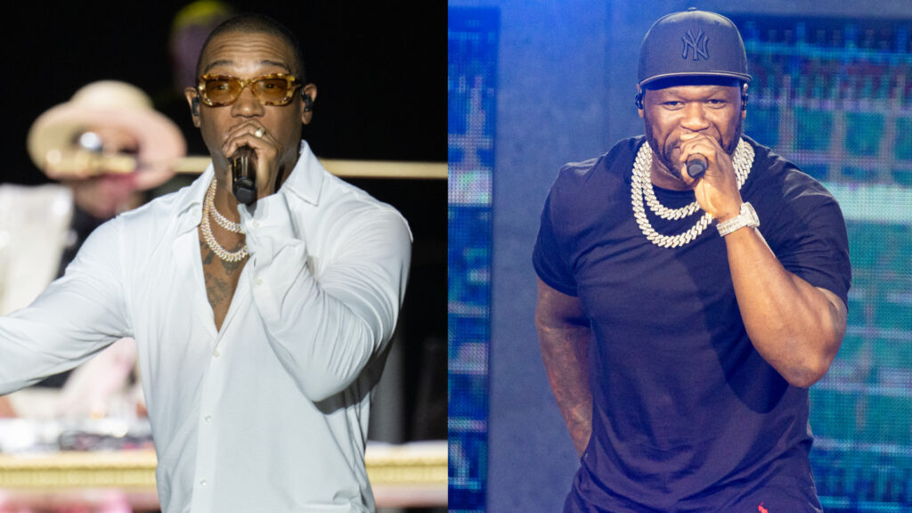 Ja Rule in a white shirt performing, and 50 Cent in a black shirt and cap, both holding microphones on stage.