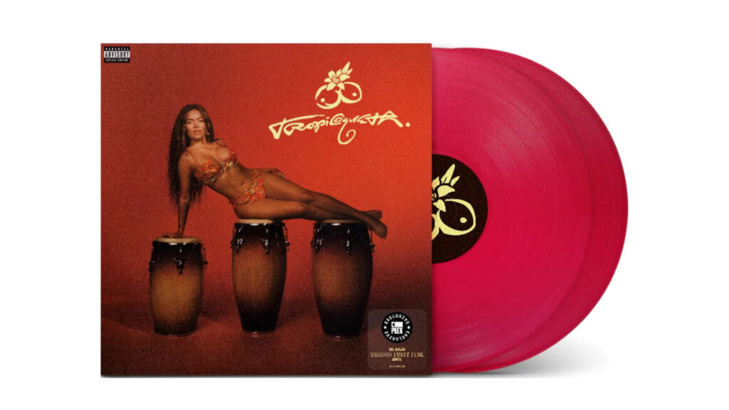 A red vinyl record with an album cover showing Karol G in a floral outfit reclining on three conga drums against a red background.