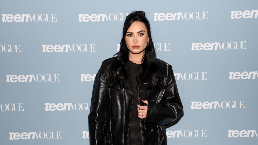 Demi Lovato Teases New Music, Wipes Instagram Demi Lovato at a Teen Vogue event, wearing a black leather jacket, with long dark hair and a neutral expression.